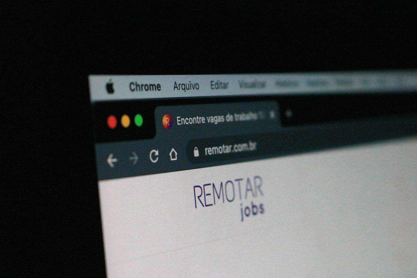 MacBook with a web browser open and a remote control resting on it