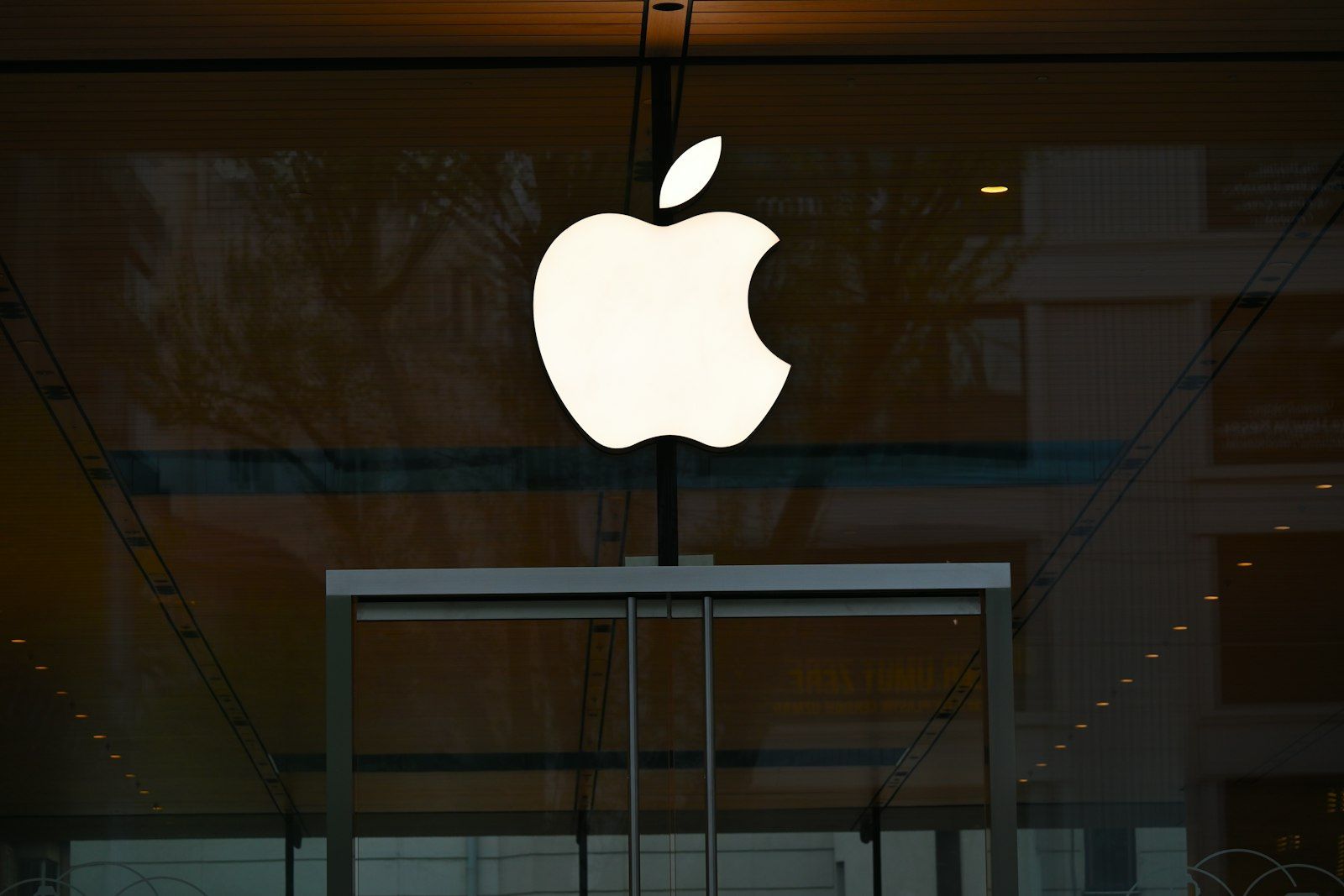 Apple logo reflected in the dark glass of a building